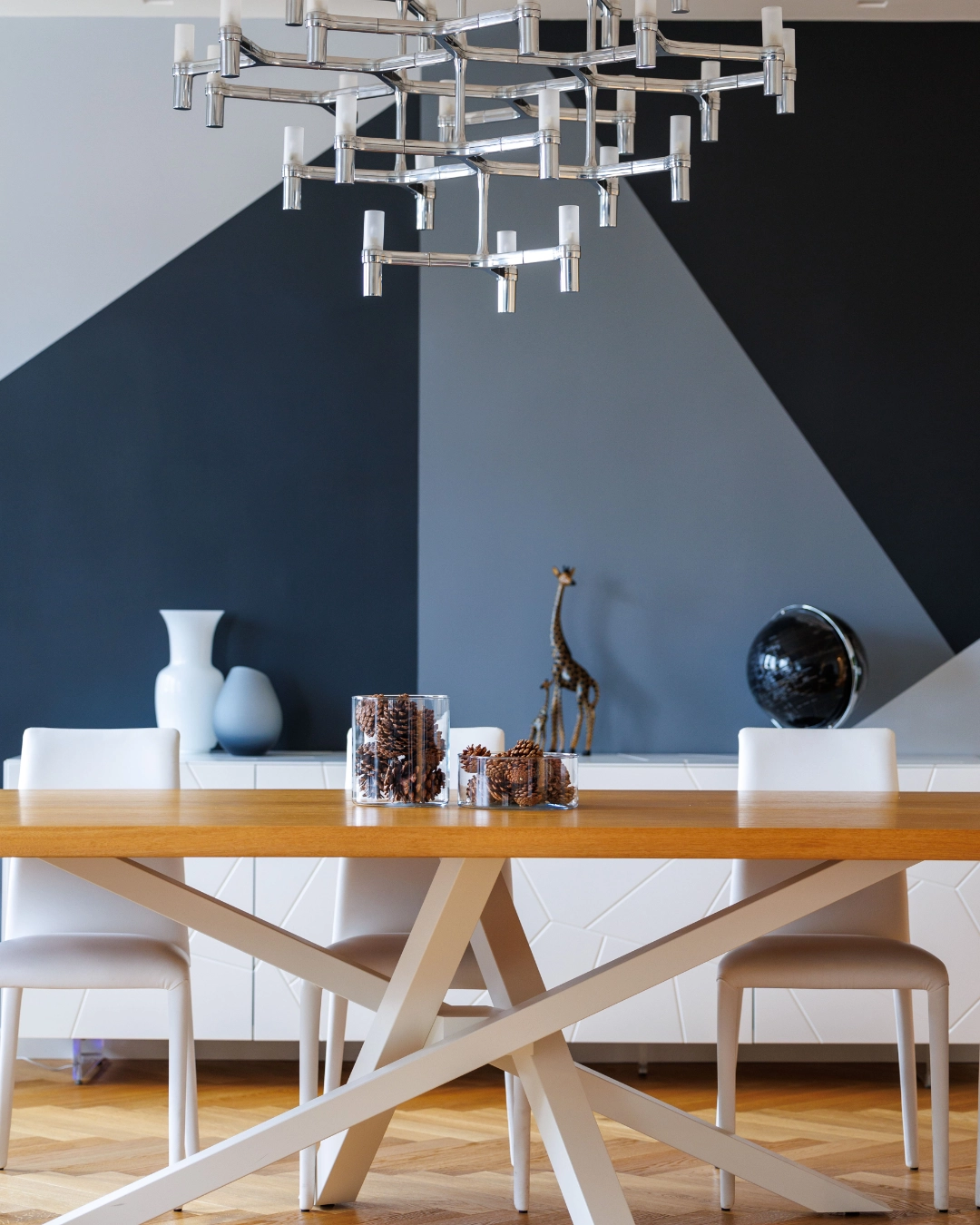 Zona pranzo con lampadario design e parete geometrica