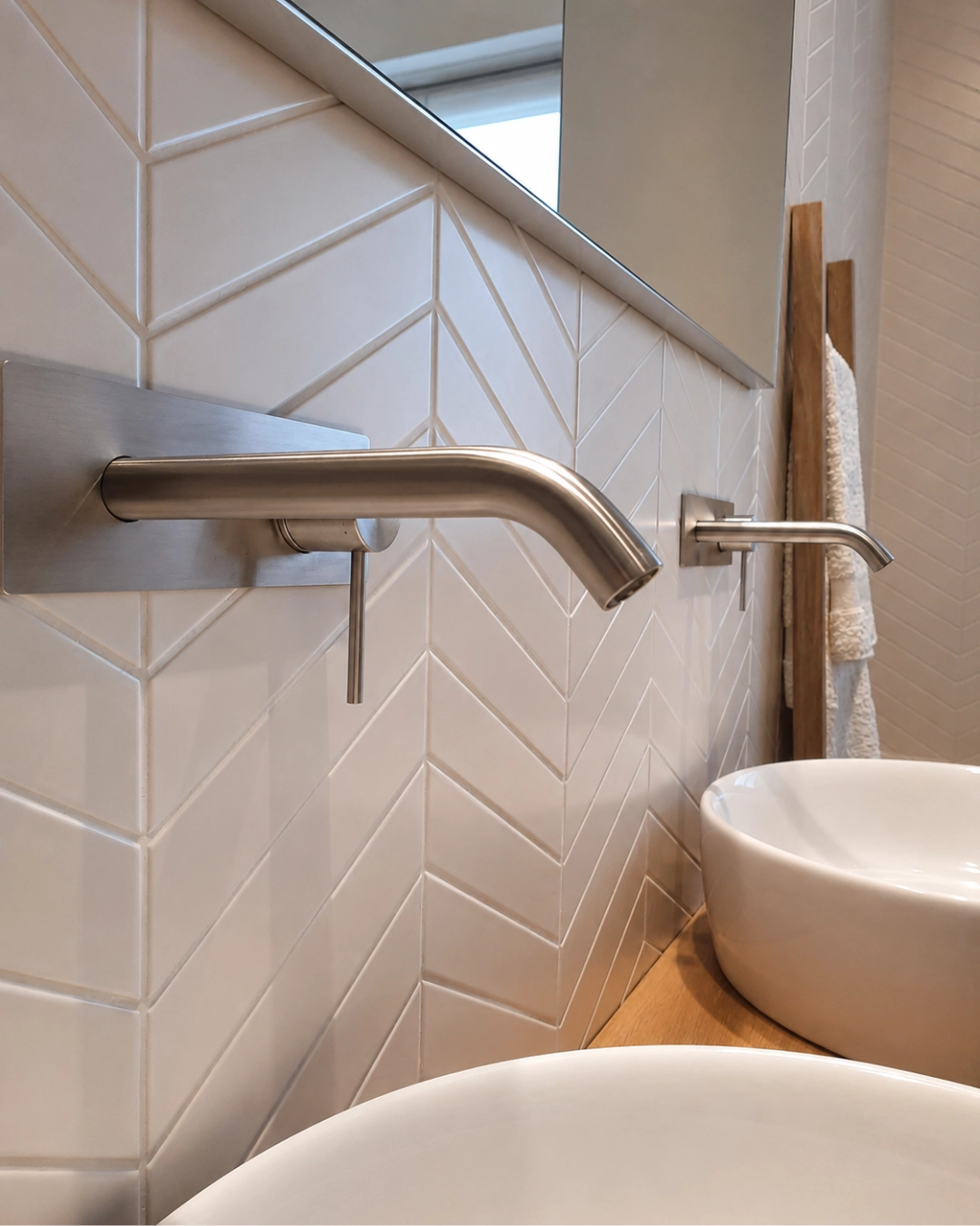 Bagno con piastrelle chevron e rubinetto a parete